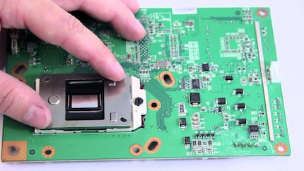 The DMD chip is the approx. 1 × 1.5 cm silver plate between the thumb and index finger.