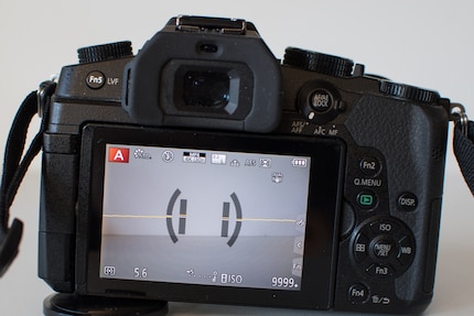 Orizzonte virtuale su una fotocamera Panasonic. Il giallo significa: attenzione, la linea è inclinata. Anche la fotocamera è inclinata (barre verticali).