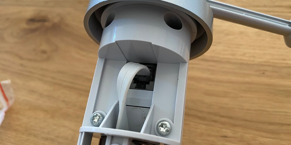 Das Kabel muss durch die Öffnung geführt und im Steckplatz untergebracht werden.
