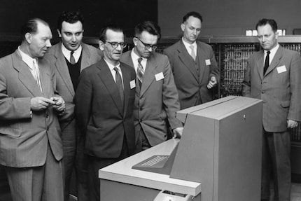 Sergueï Lebedev (3e à partir de la gauche) regarde l'ordinateur IBM avec méfiance.