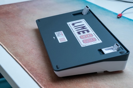 The bottom contains folding feet and a switch for either a wireless or wired connection.