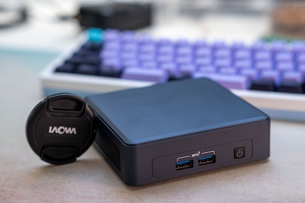NUCs like these are absolutely minuscule. My lens cap on the left even looks big next to it.