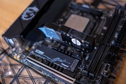 The SSD belongs under the chipset cooler. Romove the foil from the heat conducting pad.