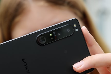 The smartphone has three small lenses instead of a single-lens reflex camera with a large lens.