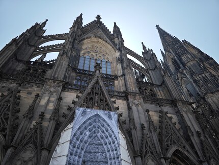 Der Kölner Dom im Schatten und mit hellem Himmel.