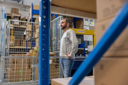 Cardboard boxes stacked up to the ceiling and service manager Mirko Pireddu in the middle of it all.