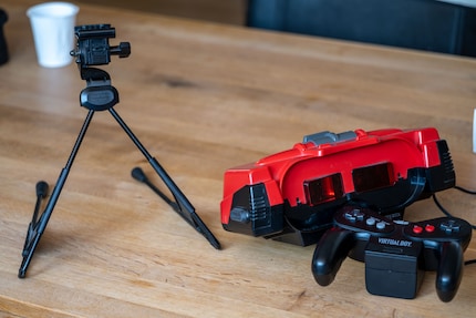 Virtual Boy (centre), manette (en bas à droite). Comme il ne se porte pas sur la tête, vous le posez sur un trépied (gauche).