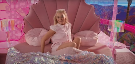 Instead of your average pillows, Barbie’s bed is filled with pink pompom-shaped velvet cushions.