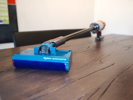 Un Dyson est accroché à l'accessoire Submarine, qui peut bien sûr aussi aspirer normalement.