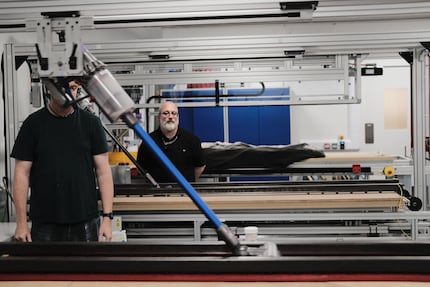 Employees test the suction power on standardised rugs.