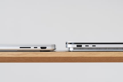 The MacBook (left) is a good 6 millimetres thinner than the Surface and has rounder outer edges.