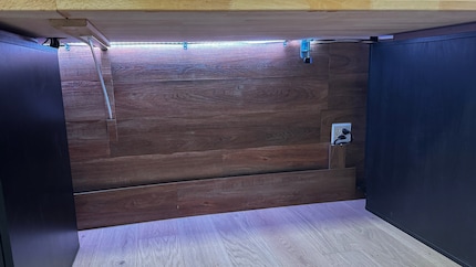 All the cables are hidden behind the wood panels under the desk.