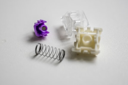 A disassembled switch. In the stem (purple), you can see the magnet that triggers a key stroke.