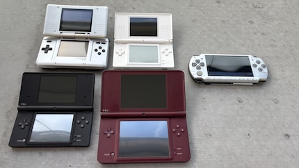 Von oben links nach unten rechts: Nintendo DS, Nintendo DS Lite, Nintendo DSi und Nintendo DSi XL. Rechts daneben die PSP.